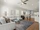 Bright, open-concept living room with hardwood floors, a gray sofa and dining area at 209 Phillips Ln, Alpharetta, GA 30009