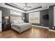 Spacious main bedroom featuring a tray ceiling, large windows, and hardwood floors at 209 Phillips Ln, Alpharetta, GA 30009