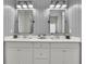 Modern bathroom with double sinks, large mirrors, contemporary lighting, and neutral walls at 4040 Grandview Manor Dr, Cumming, GA 30028