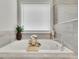 Bright bathroom featuring a soaking tub with wood-look tile surround and a large window at 4040 Grandview Manor Dr, Cumming, GA 30028
