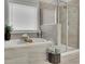 Bright bathroom featuring a soaking tub, a glass enclosed shower, and neutral tile at 4040 Grandview Manor Dr, Cumming, GA 30028
