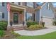 Inviting front porch with brick steps, black door, landscaping, and a two car garage at 4040 Grandview Manor Dr, Cumming, GA 30028