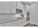 Close-up of modern kitchen with white cabinets, grey countertops, and stainless appliances at 4040 Grandview Manor Dr, Cumming, GA 30028