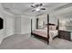 Large main bedroom featuring a four-poster bed, tray ceiling, and plush carpeting at 4040 Grandview Manor Dr, Cumming, GA 30028