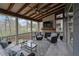 Cozy screened porch features a fireplace, ceiling fan, and relaxing outdoor furniture with wooded views at 4040 Grandview Manor Dr, Cumming, GA 30028