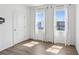 Bright bedroom featuring hardwood floors, two windows with curtains, and a white door at 2036 Bixby Byway Se Dr, Atlanta, GA 30317