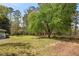 Spacious backyard featuring mature trees, a well-maintained lawn, and colorful landscaping around the house at 3960 Mason Creek Rd, Winston, GA 30187