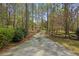 Long driveway leading to a secluded property, framed by mature trees and a rustic wooden fence at 3960 Mason Creek Rd, Winston, GA 30187