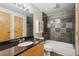 Sleek bathroom featuring a black granite countertop, tiled bathtub, and modern fixtures at 5200 Peachtree Rd # 3324, Chamblee, GA 30341