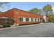 Modern red brick building with black framed windows and manicured landscaping at Peachtree Malone Lofts at 5200 Peachtree Rd # 3324, Chamblee, GA 30341