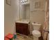 Well-lit bathroom features a vanity with dark wood cabinets, a sink, and a toilet at 605 Oak Terrace Drive, Covington, GA 30016