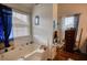 Bathroom features a large tub, tiled walls, and two windows for natural light at 605 Oak Terrace Drive, Covington, GA 30016