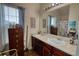 Well-lit bathroom with double sinks, framed mirror and wood cabinets offers practical elegance at 605 Oak Terrace Drive, Covington, GA 30016