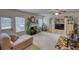 Spacious living room with a fireplace, built-in shelving, a ceiling fan, and ample natural light from the large windows at 605 Oak Terrace Drive, Covington, GA 30016