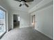 A carpeted bedroom with a ceiling fan, balcony, and two doorways for access at 195 14Th St # 1005, Atlanta, GA 30309