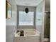 Bathroom with bathtub, shower, window and pendant lighting at 2814 Michelle Lee Dr, Dacula, GA 30019