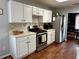 Updated kitchen showcasing white cabinets, stainless steel appliances, and hardwood flooring with a view to the dining room at 2814 Michelle Lee Dr, Dacula, GA 30019