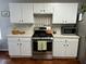 Updated kitchen featuring white cabinets, modern appliances, and hardwood floors complemented by neutral wall colors at 2814 Michelle Lee Dr, Dacula, GA 30019