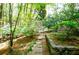 Stone path with lush landscaping, mature trees, and azalea bushes create a tranquil garden setting at 4495 Glengary Ne Dr, Atlanta, GA 30342