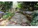 Charming stone path surrounded by lush greenery and mossy stones, creating a serene backyard oasis at 4495 Glengary Ne Dr, Atlanta, GA 30342