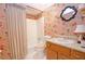 Bathroom with a shower-tub combo, colorful wallpaper, and an oak vanity at 4495 Glengary Ne Dr, Atlanta, GA 30342