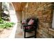 Charming front porch with stone accents, bench seating with decorative pillows, and view of the front yard landscaping at 4495 Glengary Ne Dr, Atlanta, GA 30342