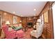 Cozy living room with rich wood paneling, a fireplace, plush seating and ornate decor at 4495 Glengary Ne Dr, Atlanta, GA 30342