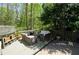 Multi-level outdoor patio featuring stylish patio furniture, mature trees, and stairs leading to the backyard at 4495 Glengary Ne Dr, Atlanta, GA 30342