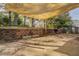 Outdoor patio with shade cover, brick retaining wall and built in grill/fire pit at 4975 Skyland Pkwy, Cumming, GA 30028