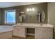 Bathroom vanity featuring dual sinks, white cabinetry, and oval mirrors illuminated by modern lighting at 4975 Skyland Pkwy, Cumming, GA 30028