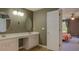 Bathroom with double vanity and doorway leading into adjacent bedroom at 4975 Skyland Pkwy, Cumming, GA 30028