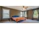 Bedroom with multiple windows, neutral carpet, ceiling fan, and natural light at 4975 Skyland Pkwy, Cumming, GA 30028