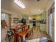 View of dining area with a large wooden table next to a kitchen with light green cabinetry at 4975 Skyland Pkwy, Cumming, GA 30028