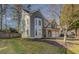 Two-story home with manicured lawn, gray siding and a two-car garage with a brick facade at 4975 Skyland Pkwy, Cumming, GA 30028