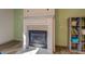 Close up of fireplace with white mantel, decorative tile and hearth, and built-in shelves at 4975 Skyland Pkwy, Cumming, GA 30028