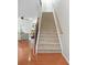 Carpeted staircase with wooden banister and a view of the living area at 5669 Cobblestone Creek Pl # 12, Mableton, GA 30126
