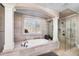 This bathroom showcases a soaking tub with decorative columns and a separate glass shower with natural light at 211 Meritage Dr, Alpharetta, GA 30022
