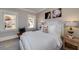 The bedroom features neutral walls, framed prints, a bed with tufted headboard, and two windows for natural light at 211 Meritage Dr, Alpharetta, GA 30022