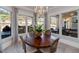 Charming dining area with a round wood table, surrounded by large windows and backyard views at 211 Meritage Dr, Alpharetta, GA 30022