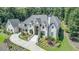 Exterior shot of house with long driveway, lush landscaping, and an attached garage at 211 Meritage Dr, Alpharetta, GA 30022