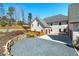 Wide view of the garages, driveway and partial lawn surrounded by stacked stone wall at 211 Meritage Dr, Alpharetta, GA 30022
