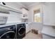 A well-organized laundry room featuring modern washer and dryer, ample storage, and a window for natural light at 211 Meritage Dr, Alpharetta, GA 30022
