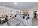Spacious living room boasts a curved sofa, elegant ottoman, and views of the billiards room for seamless entertaining at 211 Meritage Dr, Alpharetta, GA 30022