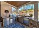Covered outdoor kitchen featuring stainless steel appliances, stone accents, and a built-in grill, perfect for outdoor entertaining at 211 Meritage Dr, Alpharetta, GA 30022