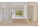 Bright bathroom features a jacuzzi tub, tiled floors, and a separate glass-door shower at 2320 Starr Lake Nw Dr, Acworth, GA 30101