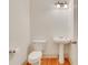 A well-lit powder room featuring white fixtures and hardwood flooring with neutral walls at 2320 Starr Lake Nw Dr, Acworth, GA 30101