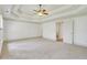 Spacious bedroom with tray ceiling, neutral carpet, and a door leading to an en-suite bathroom at 2320 Starr Lake Nw Dr, Acworth, GA 30101