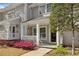 Attractive townhome with cozy front porch featuring swing and blooming landscaping at 2794 Farmstead Se Rd, Smyrna, GA 30080