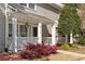 Charming front porch with white columns, hanging plants, and beautiful flowering bushes at 2794 Farmstead Se Rd, Smyrna, GA 30080