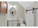Stylish powder room featuring modern vanity, toilet, and barn door at 2794 Farmstead Se Rd, Smyrna, GA 30080